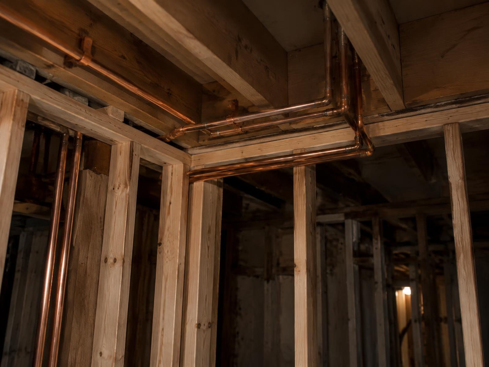 Exposed copper plumbing run in framing